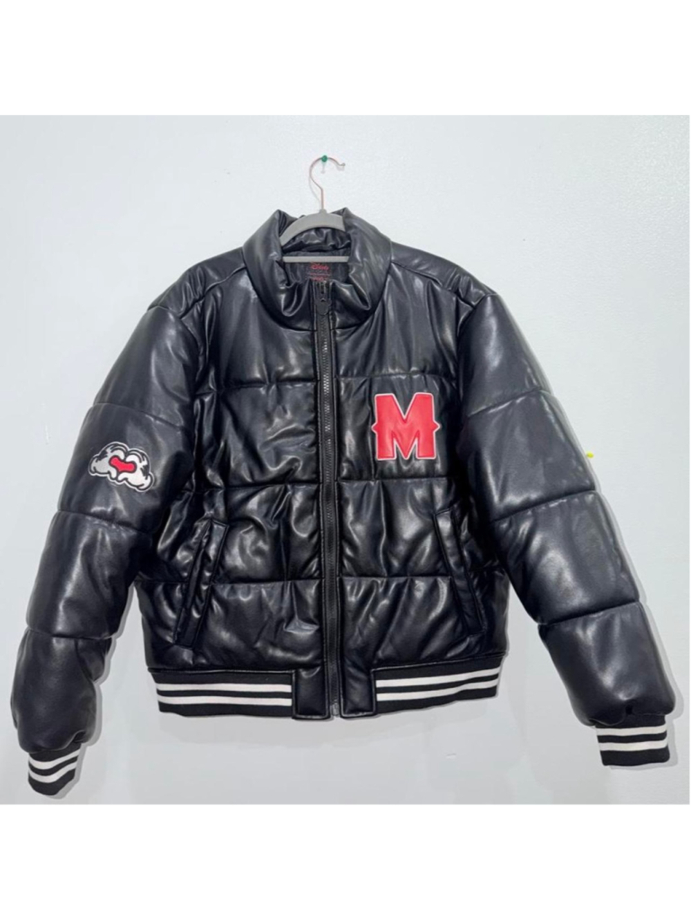 Stylish and warm black puffer jacket with a glossy finish, bold red “M” patch, u